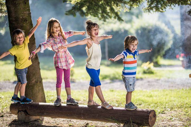 children balancing on a log